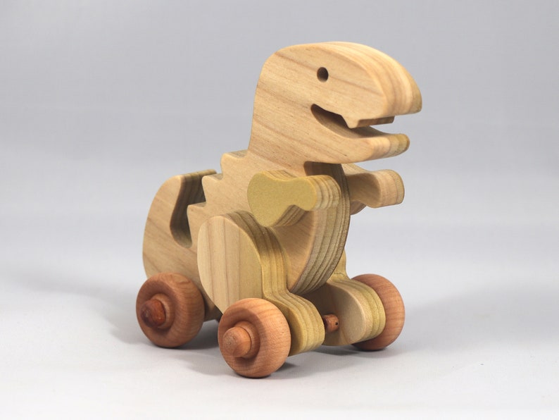 Handmade wooden push toy Tyrannosaurus Rex dinosaur made from select grade hardwoods and finished with a non-toxic coating.
