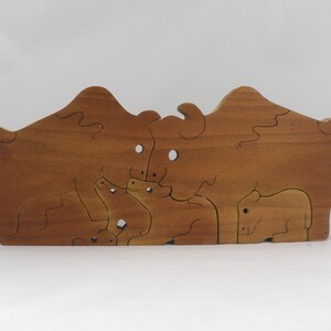 Wooden 6-piece bison family puzzle with two adult bison and four calves. The hardwood pieces interlock into one standing group or separate to stand alone. Handnmade in Tallahassee, Florida, USA by Odin's Toy Factory.