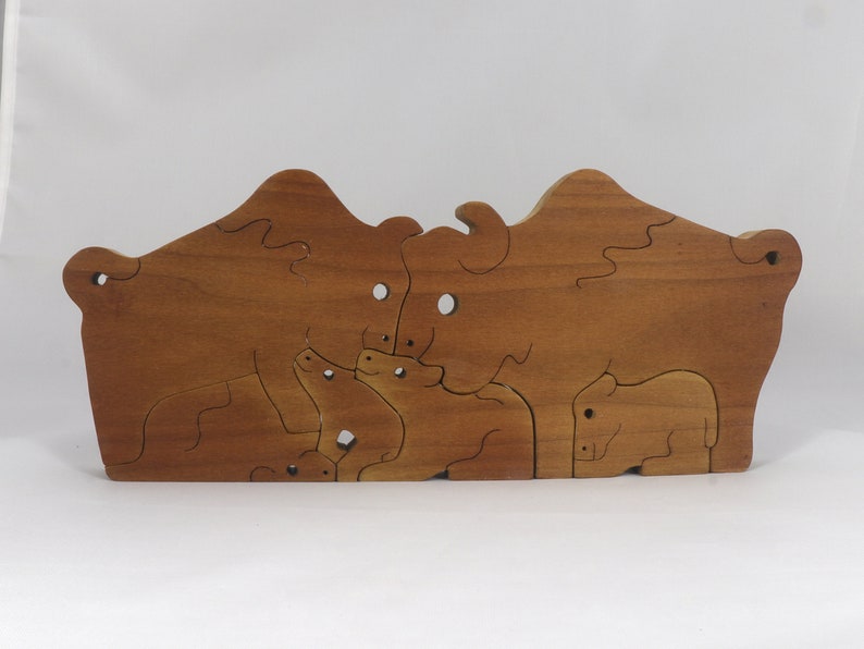 Wooden 6-piece bison family puzzle with two adult bison and four calves. The hardwood pieces interlock into one standing group or separate to stand alone. Handnmade in Tallahassee, Florida, USA by Odin's Toy Factory.