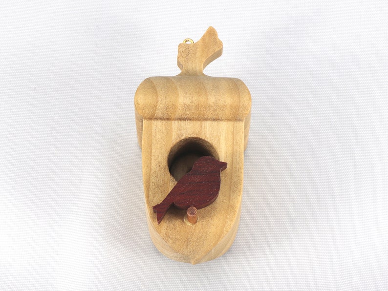 Handmade wooden miniature birdhouse ornament cut from wood with rounded edges, natural wood grain and color variations, finished with non-toxic shellac or food-safe oils and beeswax, lightweight and ready to hang. Made in Tallahassee, Florida, USA, by Odin's Toy Factory.