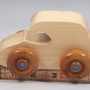 Handmade wooden toy car. The body is finished with clear shellac, and the wheels are finished with amber shellac. The hubs are painted with metallic sapphire blue trim.