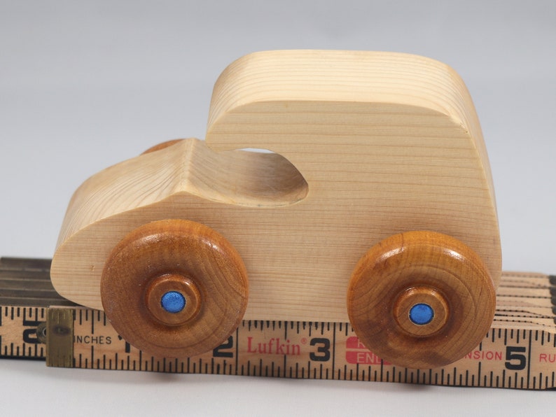 Handmade wooden toy car. The body is finished with clear shellac, and the wheels are finished with amber shellac. The hubs are painted with metallic sapphire blue trim.
