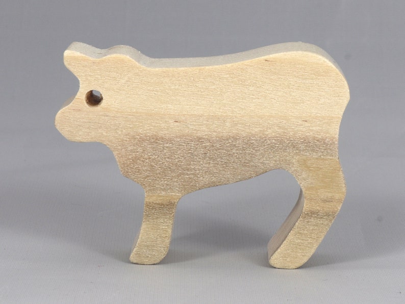 Handmade unfinished wooden toy baby calf cutout, unpainted and ready to paint, freestanding farm animal figure from Odin's Toy Factory’s  Itty Bitty Animal Collection. Handcrafted in Tallahassee, Florida, USA, using reclaimed natural wood offcuts. Perfect for imaginative play, stacking, collectors, and crafting.