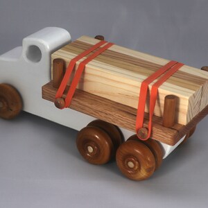 Handmade wooden toy lumber truck from Odin's Toy Factory Easy 5 Truck Fleet Collection. Painted lumber truck with acrylic body, shellac bed, and wheels. Measures approximately 9 inches long, 4 inches high, and 3.5 inches wide. Handmade in Tallahassee, Florida, USA. Custom colors available.