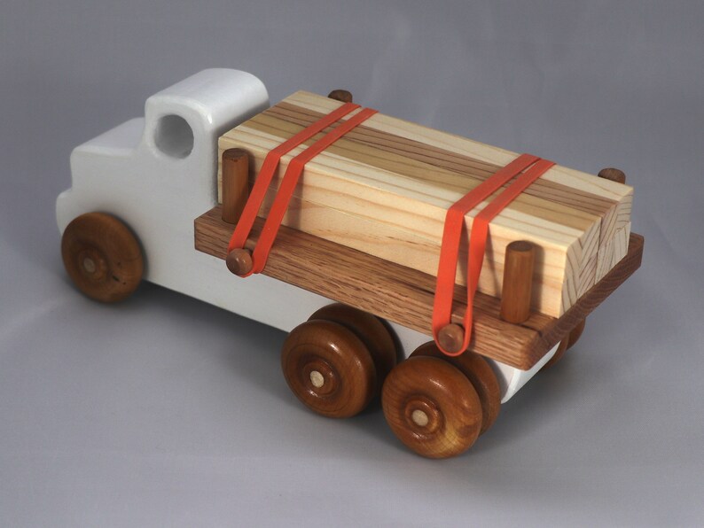 Handmade wooden toy lumber truck from Odin's Toy Factory Easy 5 Truck Fleet Collection. Painted lumber truck with acrylic body, shellac bed, and wheels. Measures approximately 9 inches long, 4 inches high, and 3.5 inches wide. Handmade in Tallahassee, Florida, USA. Custom colors available.
