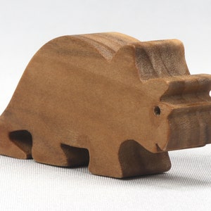 This small wooden triceratops dinosaur toy is crafted from high-quality hardwood and hand-finished. It is a delightful plaything for young children and appeals to many adults.