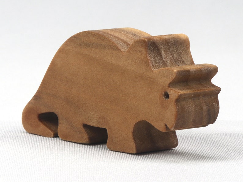 This small wooden triceratops dinosaur toy is crafted from high-quality hardwood and hand-finished. It is a delightful plaything for young children and appeals to many adults.