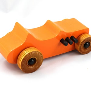 Handmade wooden toy car modeled after a 1927 T-Bucket hot rod. Finished with orange and black acrylic paint and amber shellac.