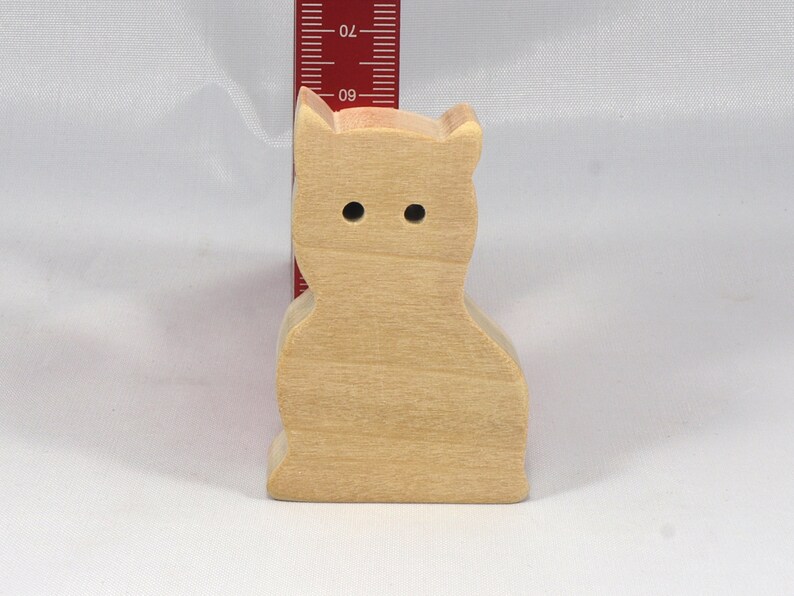 A handmade freestanding wooden toy cat cutout 1/2-3/4 inches thick is made from various kinds of wood sanded smooth and ready to paint. It is excellent for kids' crafts, pretend, or stacking toys. Other sizes are available with a custom order.