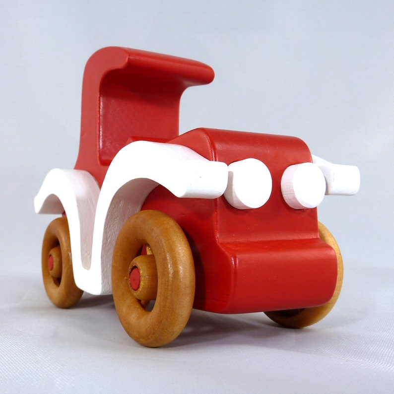 Handmade wooden toy car, vintage style red Model T Coupe by Odin's Toy Factory. Two-tone red and white acrylic paint with spoked wooden wheels finished in amber shellac. Approximate dimensions: 5 inches long, 4 inches high, 2.5 inches wide. Part of Bad Bob’s Custom Motors Collection. Crafted from natural wood using traditional woodworking tools. Handmade in Tallahassee, Florida, USA.