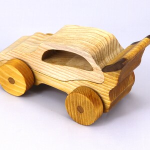 Handmade wooden toy car finished with nontoxic clear amber shellac and contrasting wood trim. Part of the Speedy Wheels Collection. Handcrafted in Tallahassee, Florida, USA. Length 5-1/2 inches, width 2-1/2 inches, height 2-1/2 inches. Made at Odin's Toy Factory.