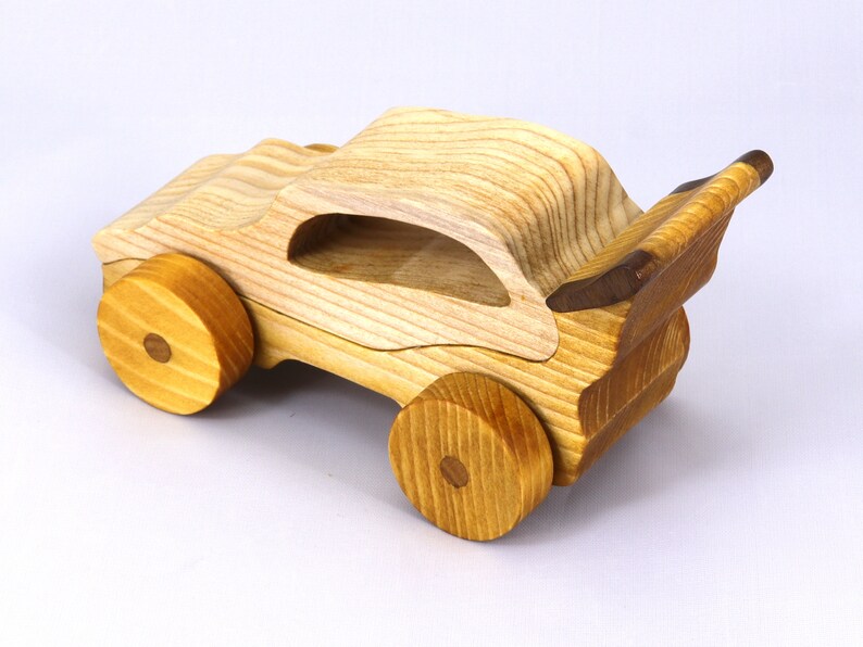 Handmade wooden toy car finished with nontoxic clear amber shellac and contrasting wood trim. Part of the Speedy Wheels Collection. Handcrafted in Tallahassee, Florida, USA. Length 5-1/2 inches, width 2-1/2 inches, height 2-1/2 inches. Made at Odin's Toy Factory.