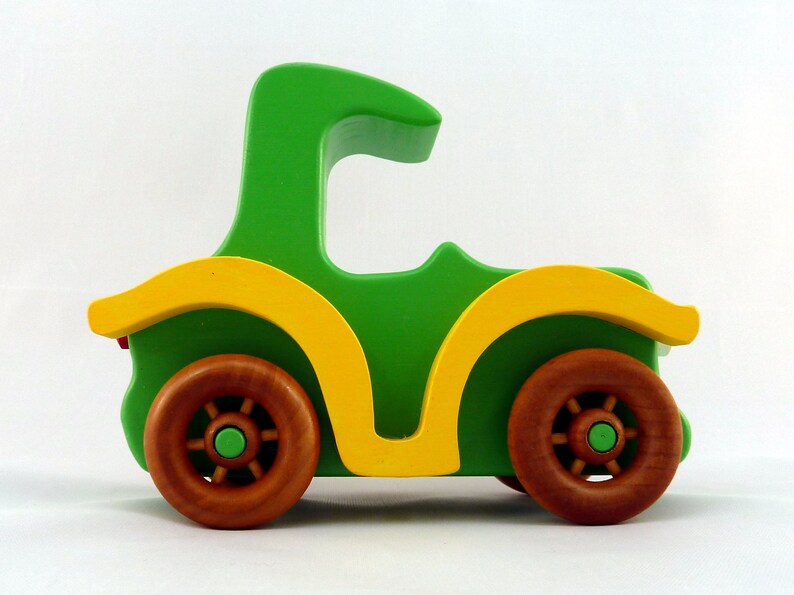Handmade wooden toy car, vintage-style Model T sedan, painted bright green and yellow with spoked wheels, finished in amber shellac.  Handcrafted in Tallahassee, Florida, USA by Odin's Toy Factory.