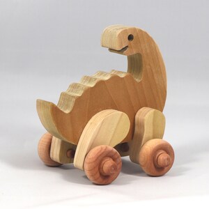Handmade wooden push toy dinosaur made from select grade hardwoods and finished with a non-toxic coating.