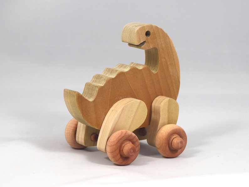 Handmade wooden push toy dinosaur made from select grade hardwoods and finished with a non-toxic coating.