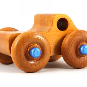 Wood Toy Monster Truck Handmade Form Hardwood and Finished With Amber Shellac With Metallic Saphire Blue Trim.