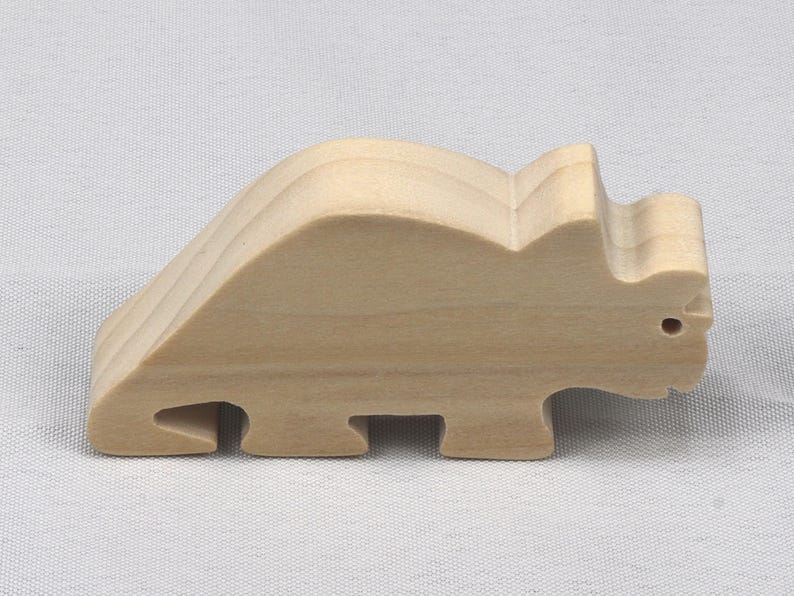 This is an unfinished wooden Wooden Toy Dinosaur Triceratops cutout from solid wood using traditional woodworking techniques. Sanded smooth and ready to paint, stain, or customize. Freestanding design for small hands, toddlers, young children, crafters, collectors, and display. I take custom orders for any animal, quantity, and mix — including large ornament orders. Mix and match, request a different size, or send a drawing or pattern. Handmade by Odin's Toy Factory in Tallahassee, Florida, USA.