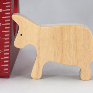 A handmade and unfinished wooden toy cow cutout is perfect for those who love to paint and customize their toys. It is freestanding and stackable, making it a versatile addition to any playroom or nursery. From My Itty Bitty Animal Collection.