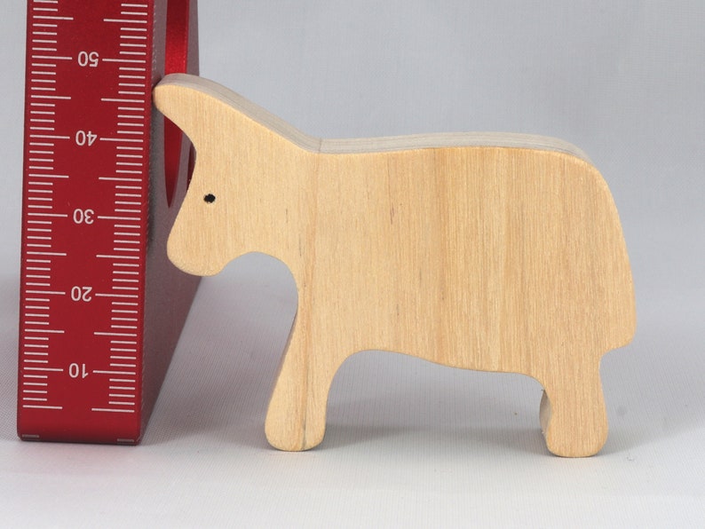 A handmade and unfinished wooden toy cow cutout is perfect for those who love to paint and customize their toys. It is freestanding and stackable, making it a versatile addition to any playroom or nursery. From My Itty Bitty Animal Collection.