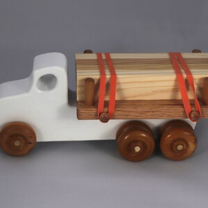 Handmade wooden toy lumber truck from Odin's Toy Factory Easy 5 Truck Fleet Collection. Painted lumber truck with acrylic body, shellac bed, and wheels. Measures approximately 9 inches long, 4 inches high, and 3.5 inches wide. Handmade in Tallahassee, Florida, USA. Custom colors available.