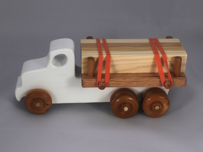 Handmade wooden toy lumber truck from Odin's Toy Factory Easy 5 Truck Fleet Collection. Painted lumber truck with acrylic body, shellac bed, and wheels. Measures approximately 9 inches long, 4 inches high, and 3.5 inches wide. Handmade in Tallahassee, Florida, USA. Custom colors available.