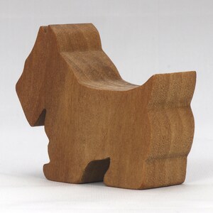 Handmade wooden Scottie dog toy cutout finished with mineral oil and beeswax blend. Freestanding stackable design from my Itty Bitty Animal Collection. Handcrafted in Tallahassee, Florida, USA from quality hardwood. Approximate size: length 2-1/2 inches, height 2 inches, width 3/4 inch. Each piece is unique with natural wood grain variations.