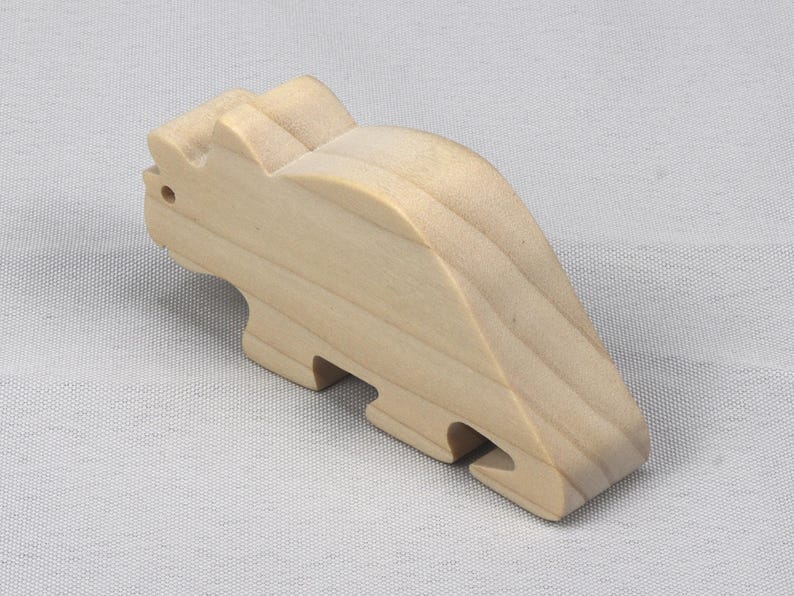 This is an unfinished wooden Wooden Toy Dinosaur Triceratops cutout from solid wood using traditional woodworking techniques. Sanded smooth and ready to paint, stain, or customize. Freestanding design for small hands, toddlers, young children, crafters, collectors, and display. I take custom orders for any animal, quantity, and mix — including large ornament orders. Mix and match, request a different size, or send a drawing or pattern. Handmade by Odin's Toy Factory in Tallahassee, Florida, USA.