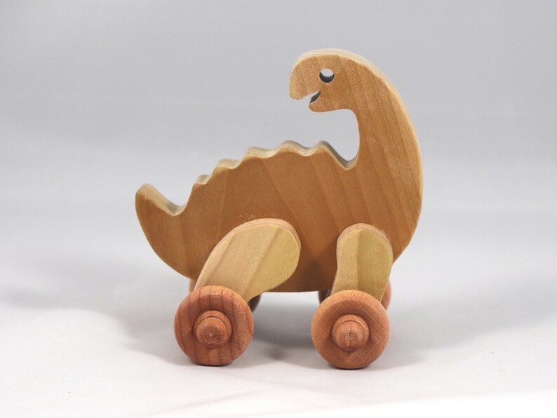 Handmade wooden push toy dinosaur made from select grade hardwoods and finished with a non-toxic coating.