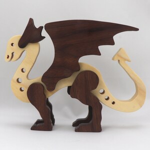 Handmade wooden dragon figurine made from contrasting hardwoods with a light natural wood body and head paired with rich dark reddish-brown wings, legs, and horns.