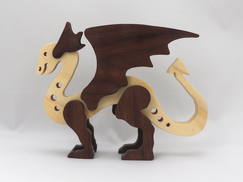 Handmade wooden dragon figurine made from contrasting hardwoods with a light natural wood body and head paired with rich dark reddish-brown wings, legs, and horns.