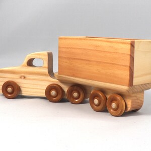 Handmade wooden toy tractor trailer semi truck finished with clear shellac. Crafted from natural wood using traditional woodworking tools. Approximate size 7 inches long. Made in Tallahassee, Florida, USA from Odin's Toy Factory Play Pal Collection.