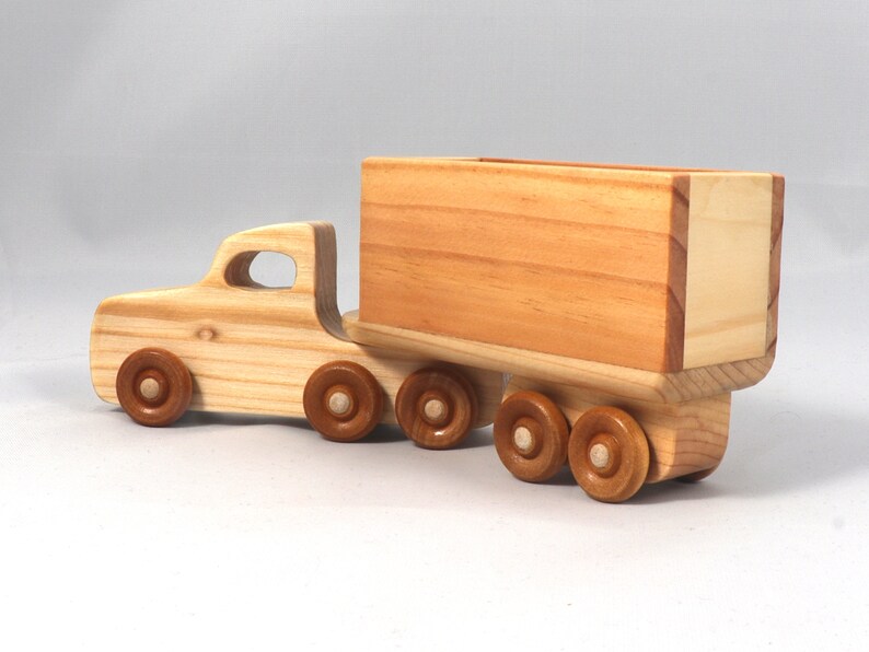 Handmade wooden toy tractor trailer semi truck finished with clear shellac. Crafted from natural wood using traditional woodworking tools. Approximate size 7 inches long. Made in Tallahassee, Florida, USA from Odin's Toy Factory Play Pal Collection.