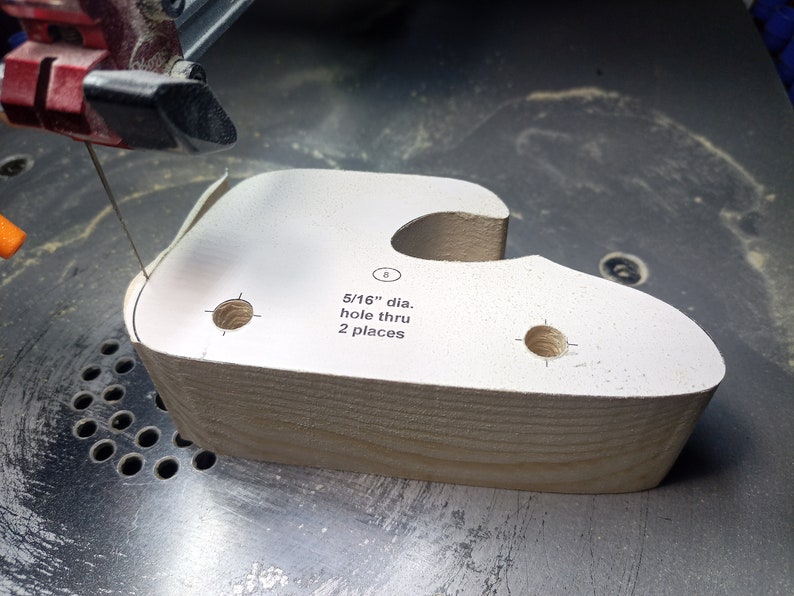 Handmade wooden toy car. The body is finished with clear shellac, and the wheels are finished with amber shellac. The hubs are painted with metallic sapphire blue trim. Cutting with a scroll saw.