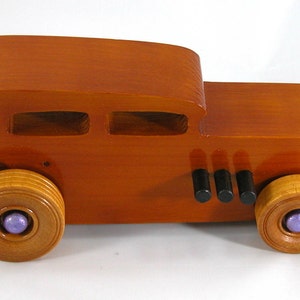 This is a handmade wooden toy car modeled after a Hot Rod 1932 Ford Sedan. It is made from wood, finished with multiple coats of amber shellac, and trimmed with black and metallic purple acrylic paint.