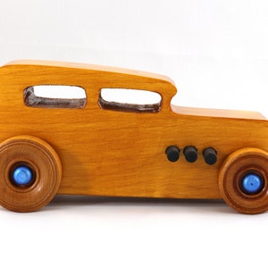 Handcrafted wooden hot rod toy car modeled after a classic '32 sedan. Finished with amber shellac and adorned with metallic sapphire blue and black trim. This unique piece is part of my Hot Rod Collection.