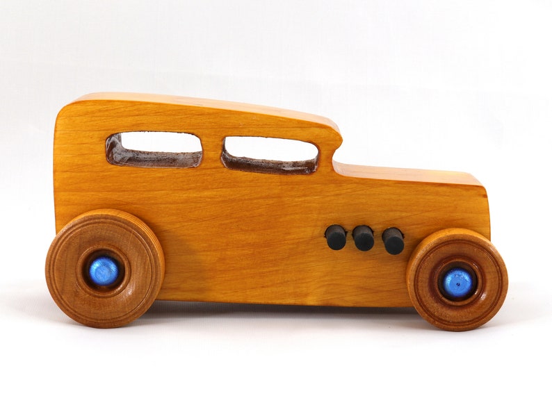 Handcrafted wooden hot rod toy car modeled after a classic '32 sedan. Finished with amber shellac and adorned with metallic sapphire blue and black trim. This unique piece is part of my Hot Rod Collection.