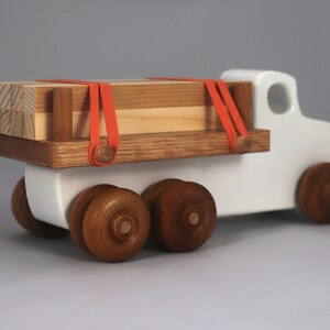 Handmade wooden toy lumber truck from Odin's Toy Factory Easy 5 Truck Fleet Collection. Painted lumber truck with acrylic body, shellac bed, and wheels. Measures approximately 9 inches long, 4 inches high, and 3.5 inches wide. Handmade in Tallahassee, Florida, USA. Custom colors available.
