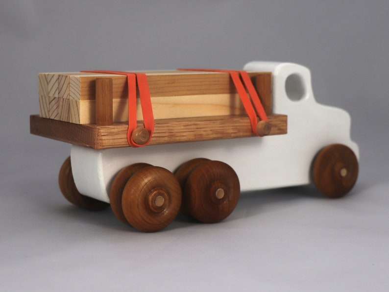Handmade wooden toy lumber truck from Odin's Toy Factory Easy 5 Truck Fleet Collection. Painted lumber truck with acrylic body, shellac bed, and wheels. Measures approximately 9 inches long, 4 inches high, and 3.5 inches wide. Handmade in Tallahassee, Florida, USA. Custom colors available.