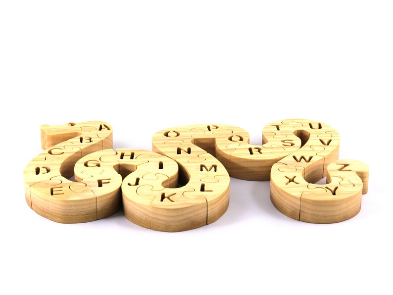 Hand-cut Alphabet Snake Puzzle made from premium hardwood, finished with mineral oil and beeswax for durability. Each of the 26 pieces represents a letter, promoting alphabet learning and essential skills development in kids through play.