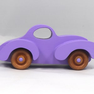 A Handmade Wood Toy Car Fat Fendered Coupe Hand Painted With Amethyst Acrylic Paint And Amber Shellac