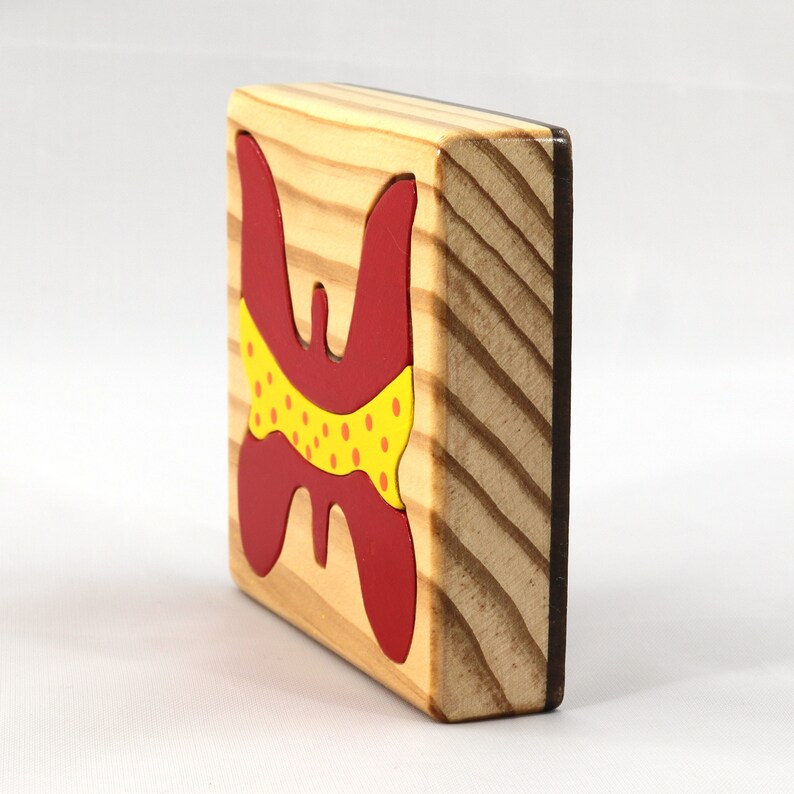 A wooden three-piece butterfly tray puzzle, handmade and finished. The butterfly is painted bright red and yellow with orange spots. The wooden tray is finished with clear shellac. It is one of four puzzles in my Puzzle Pals Collection.