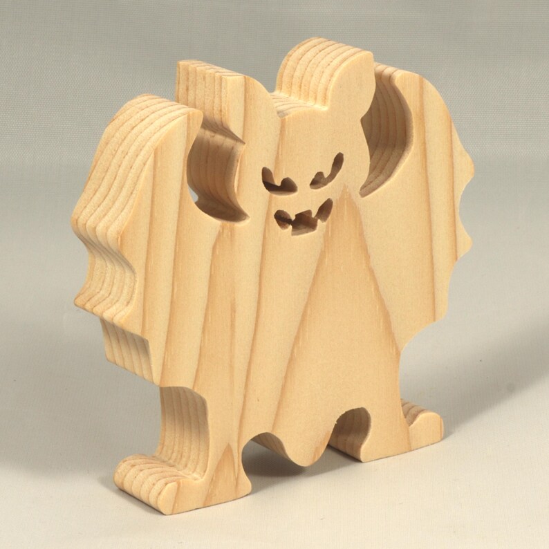 Handmade unpainted wooden Halloween bat cutout, freestanding light-colored solid wood figure with spooky carved face and outstretched wings, ready to paint, from my Snazzy Spooks collection.