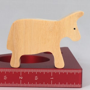 A handmade and unfinished wooden toy cow cutout is perfect for those who love to paint and customize their toys. It is freestanding and stackable, making it a versatile addition to any playroom or nursery. From My Itty Bitty Animal Collection.