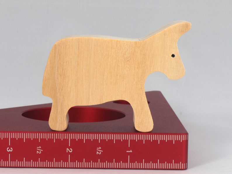 A handmade and unfinished wooden toy cow cutout is perfect for those who love to paint and customize their toys. It is freestanding and stackable, making it a versatile addition to any playroom or nursery. From My Itty Bitty Animal Collection.