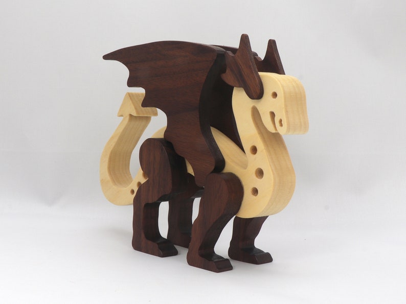Handmade wooden dragon figurine made from contrasting hardwoods with a light natural wood body and head paired with rich dark reddish-brown wings, legs, and horns.