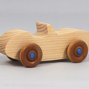 Handmade wooden toy car convertible sports coupe with a nontoxic satin polyethylene finish, amber shellac wheels, and metallic sapphire blue trim.