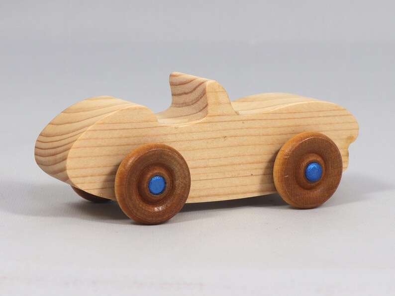 Handmade wooden toy car convertible sports coupe with a nontoxic satin polyethylene finish, amber shellac wheels, and metallic sapphire blue trim.