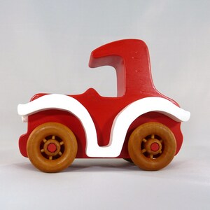 Handmade wooden toy car, vintage style red Model T Coupe by Odin's Toy Factory. Two-tone red and white acrylic paint with spoked wooden wheels finished in amber shellac. Approximate dimensions: 5 inches long, 4 inches high, 2.5 inches wide. Part of Bad Bob’s Custom Motors Collection. Crafted from natural wood using traditional woodworking tools. Handmade in Tallahassee, Florida, USA.