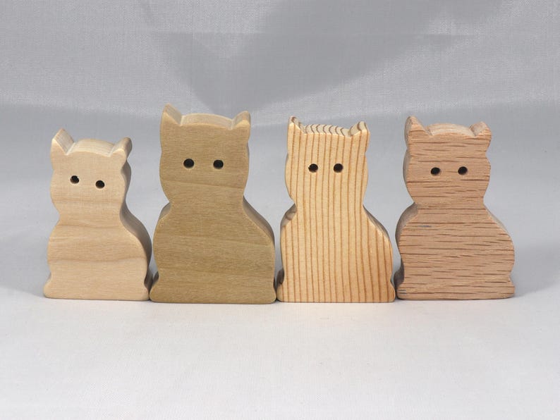 This is an unfinished wooden Sitting Cat cutout from solid wood using traditional woodworking techniques. Sanded smooth and ready to paint, stain, or customize. Freestanding design for small hands, toddlers, young children, crafters, collectors, and display. I take custom orders for any animal, quantity, and mix — including large ornament orders. Mix and match, request a different size, or send a drawing or pattern. Handmade by Odin's Toy Factory in Tallahassee, Florida, USA.