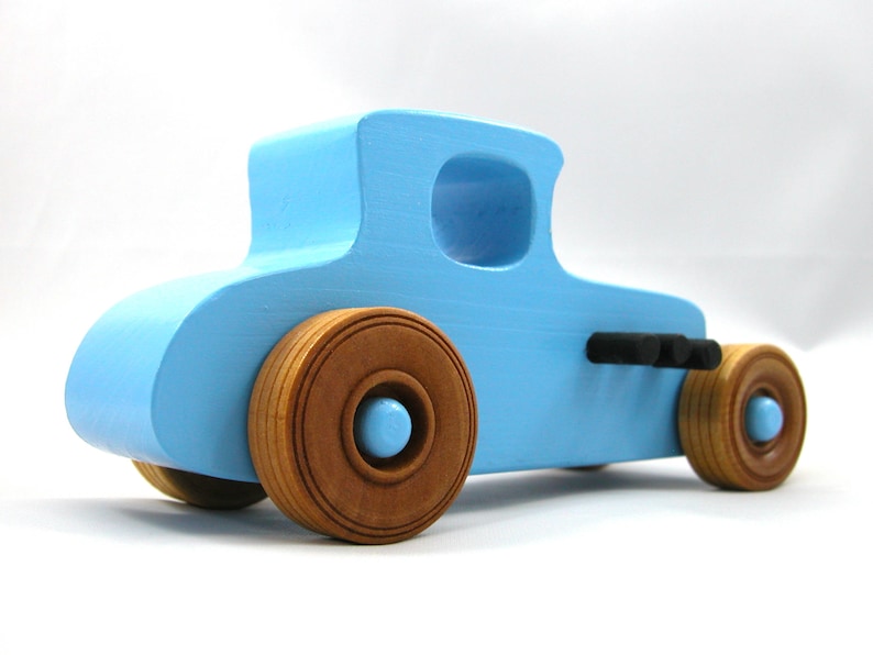 Handmade wooden toy car modeled after a '27 T-Coupe, finished with baby blue and black acrylic paint with nonmarring amber shellac wheels from my hot rod collection.